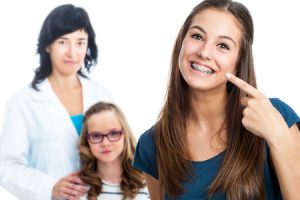 teen girl pointing at dental braces